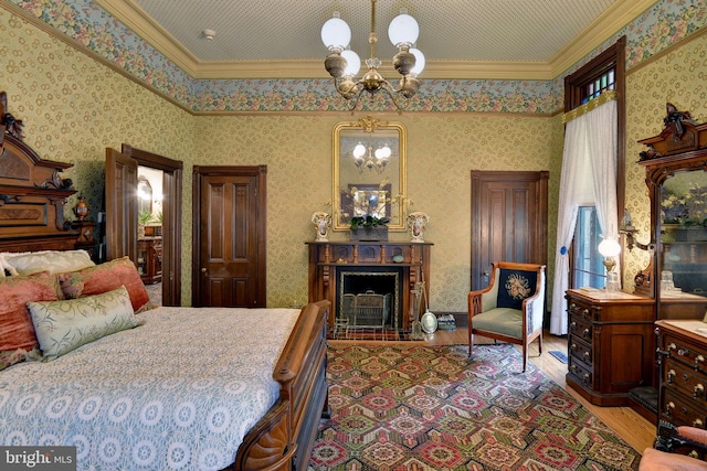 bedroom with a notable chandelier, crown molding, and light hardwood / wood-style flooring