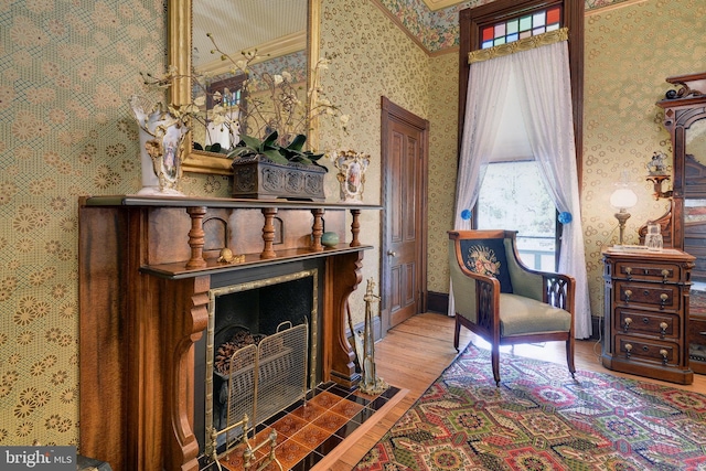 sitting room featuring a tile fireplace and hardwood / wood-style flooring