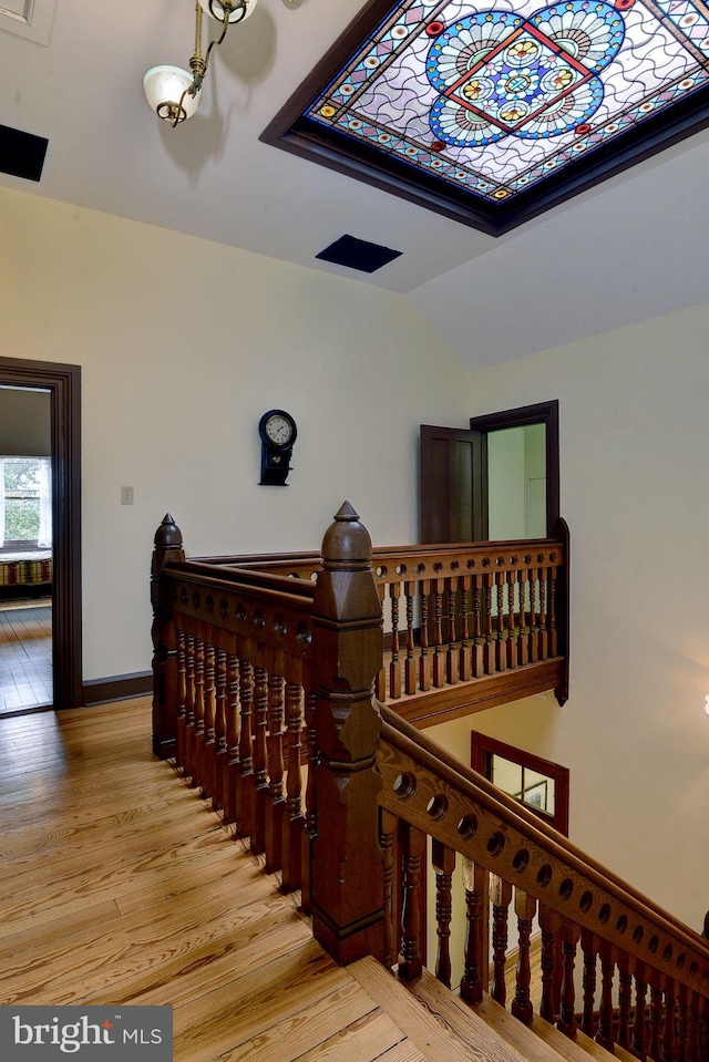 staircase with hardwood / wood-style floors and lofted ceiling