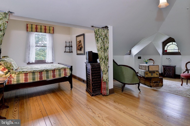 bedroom with vaulted ceiling and light hardwood / wood-style flooring