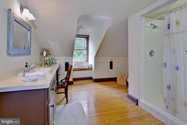 bathroom featuring a shower with curtain, vanity, wood-type flooring, and vaulted ceiling