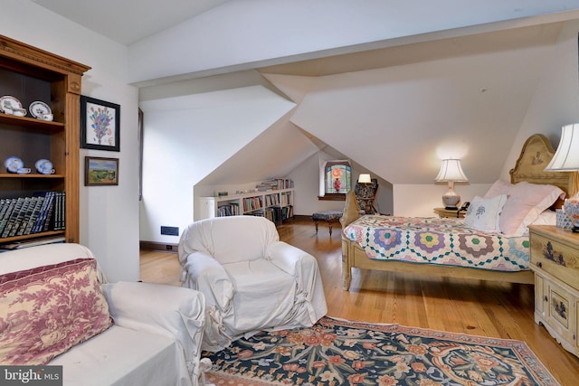 bedroom featuring lofted ceiling and light wood-type flooring