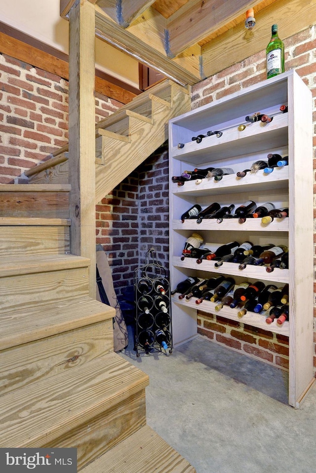 wine area featuring concrete floors and brick wall