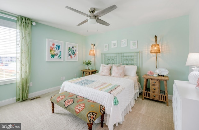 bedroom featuring multiple windows, light carpet, and ceiling fan