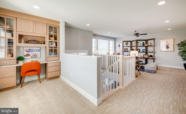 interior space with ceiling fan and built in desk