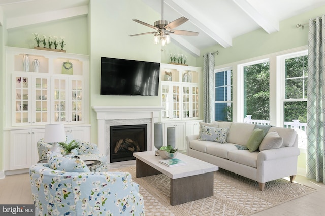 sunroom with a premium fireplace, vaulted ceiling with beams, and ceiling fan