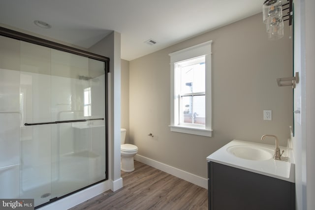 bathroom with a shower with shower door, vanity, toilet, and hardwood / wood-style floors