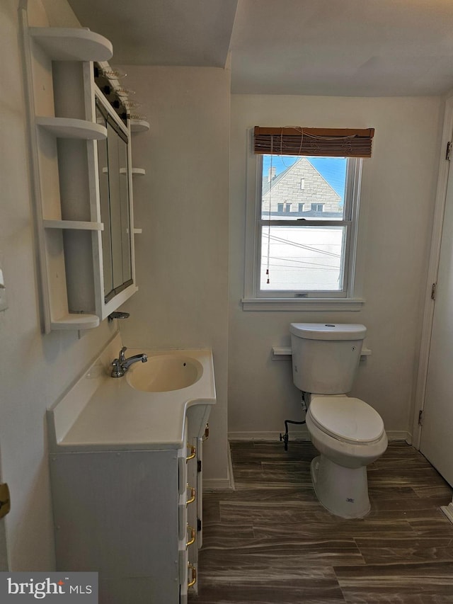 bathroom with wood-type flooring, toilet, and vanity