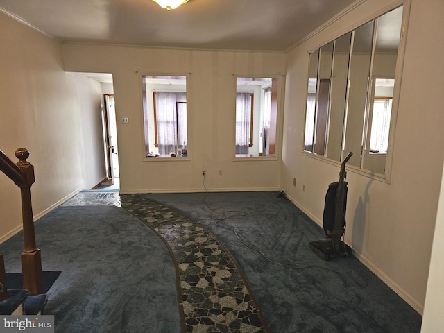 unfurnished living room with baseboards, carpet floors, and crown molding