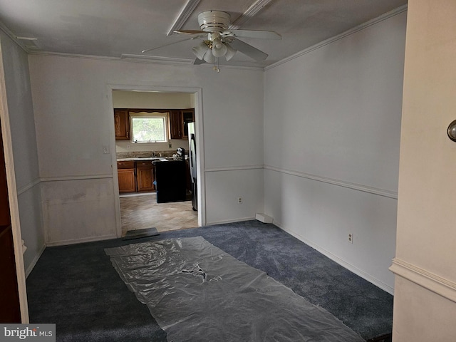 spare room featuring carpet flooring, ceiling fan, and ornamental molding