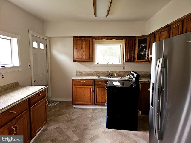 kitchen with stainless steel fridge, sink, and black / electric stove