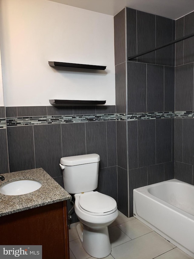 full bathroom featuring tile floors, tile walls, toilet, and vanity