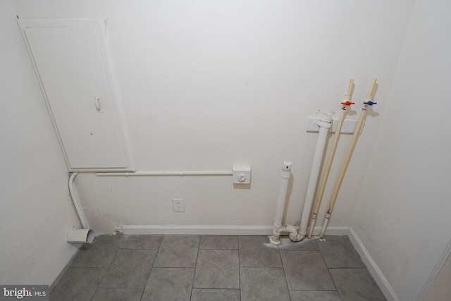 laundry room with dark tile flooring