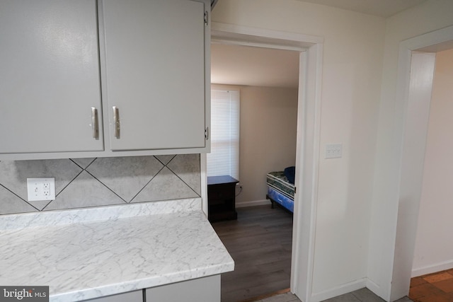 kitchen featuring gray cabinets, dark hardwood / wood-style floors, and light stone counters