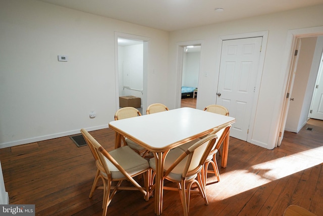 dining space with dark wood-type flooring