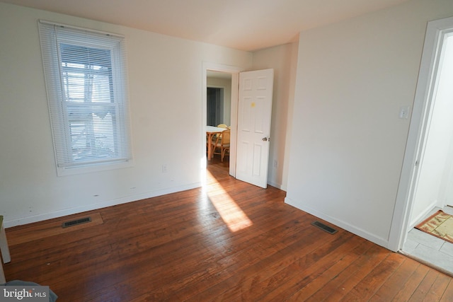 unfurnished room featuring dark hardwood / wood-style floors and a healthy amount of sunlight