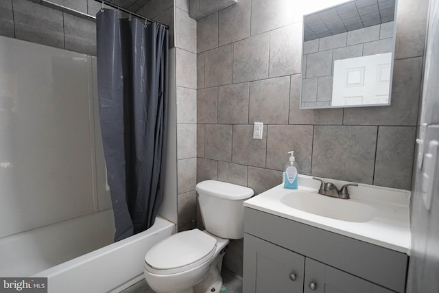 full bathroom with tile walls, shower / bath combination with curtain, toilet, and large vanity