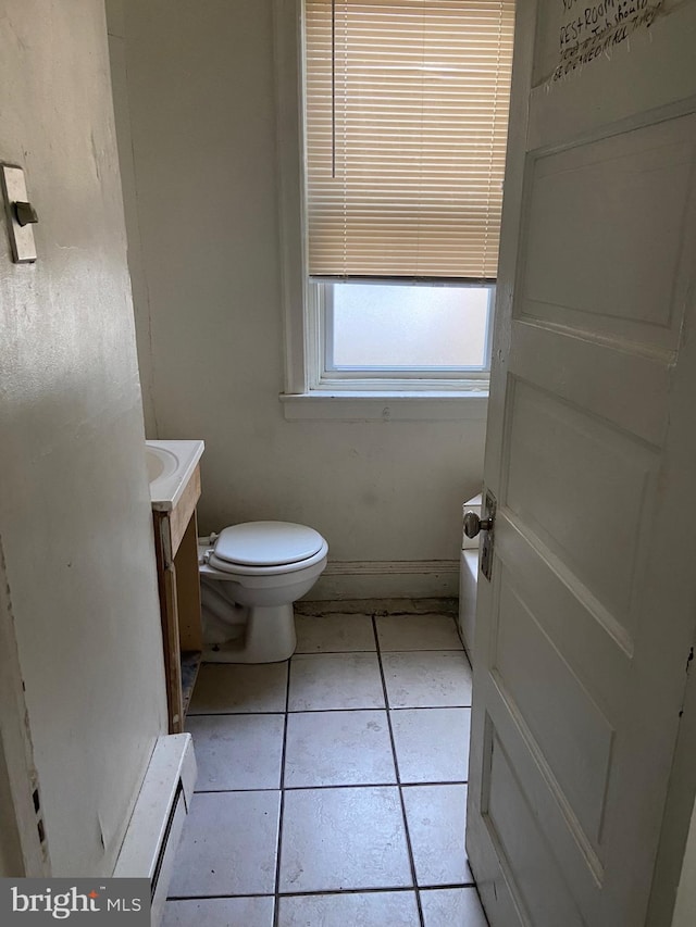 bathroom featuring tile flooring, toilet, and vanity