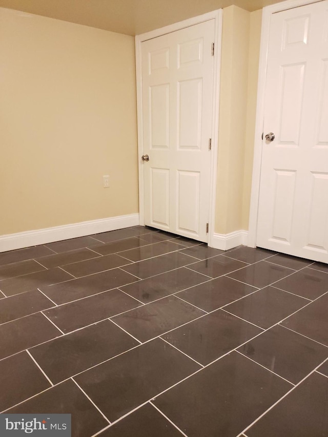 spare room featuring dark tile patterned floors