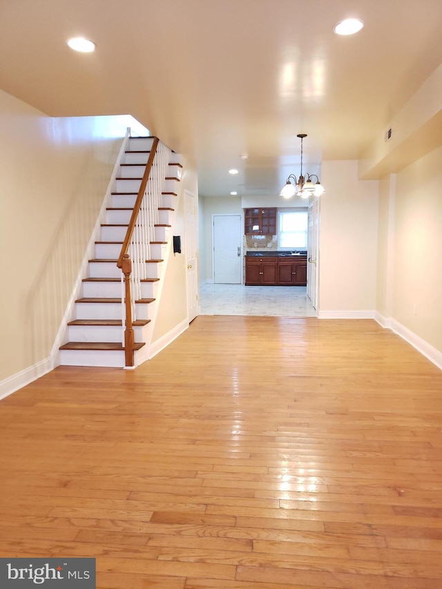 2615 N 12th St, Philadelphia, PA 19133 - unfurnished living room featuring an inviting chandelier, light wood-style flooring, stairs, baseboards, and recessed lighting