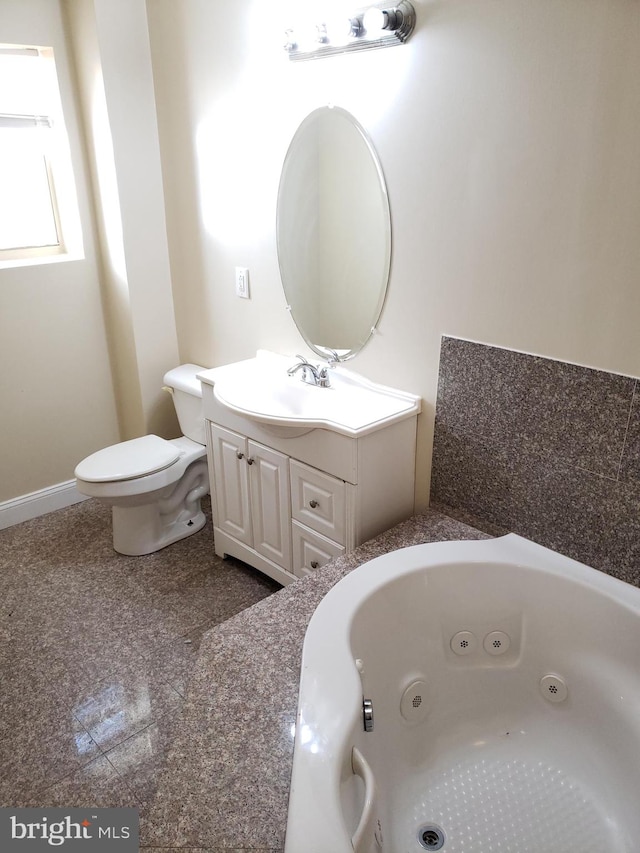 bathroom featuring vanity, toilet, and a washtub