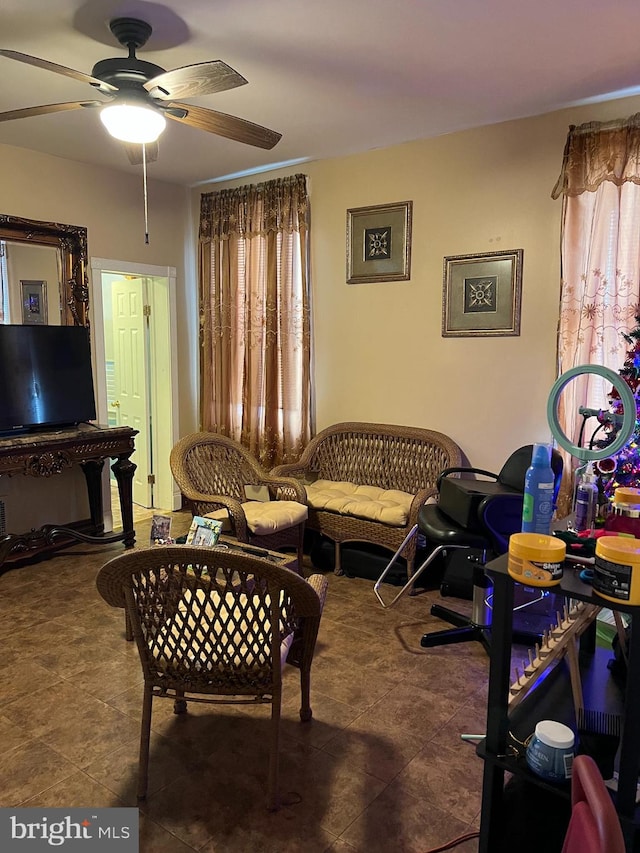 living room with dark tile floors and ceiling fan