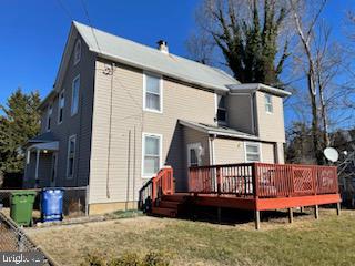 rear view of house featuring a wooden deck and a yard