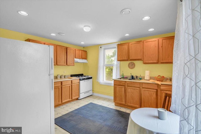 kitchen featuring white appliances, light tile flooring, and sink