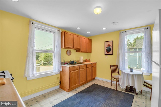 kitchen with light tile flooring, sink, and white range oven