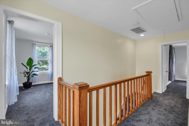 hall featuring dark colored carpet