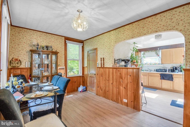 office area with crown molding, a notable chandelier, and light wood-type flooring