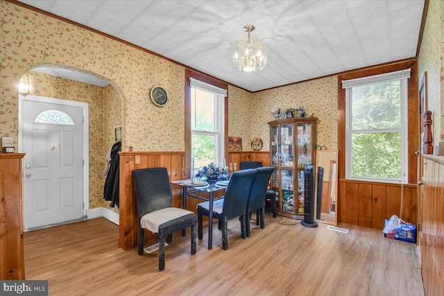 dining area featuring a notable chandelier, crown molding, and light wood-type flooring