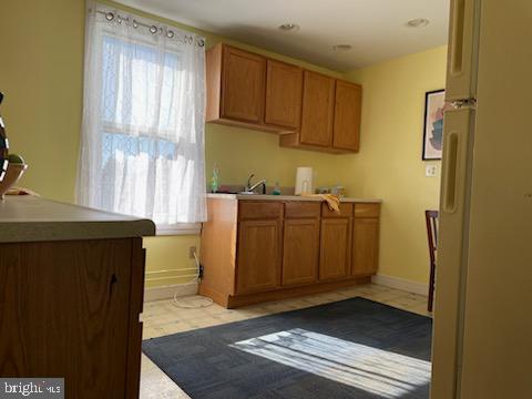 kitchen with light tile floors and white refrigerator