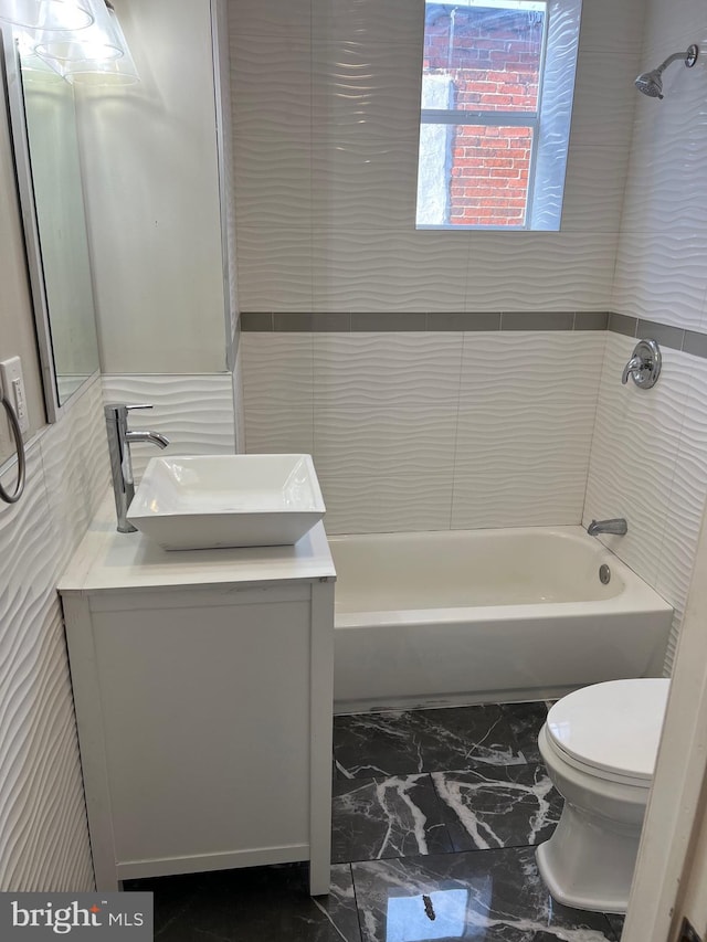 full bathroom with tile floors, toilet, vanity, and tiled shower / bath