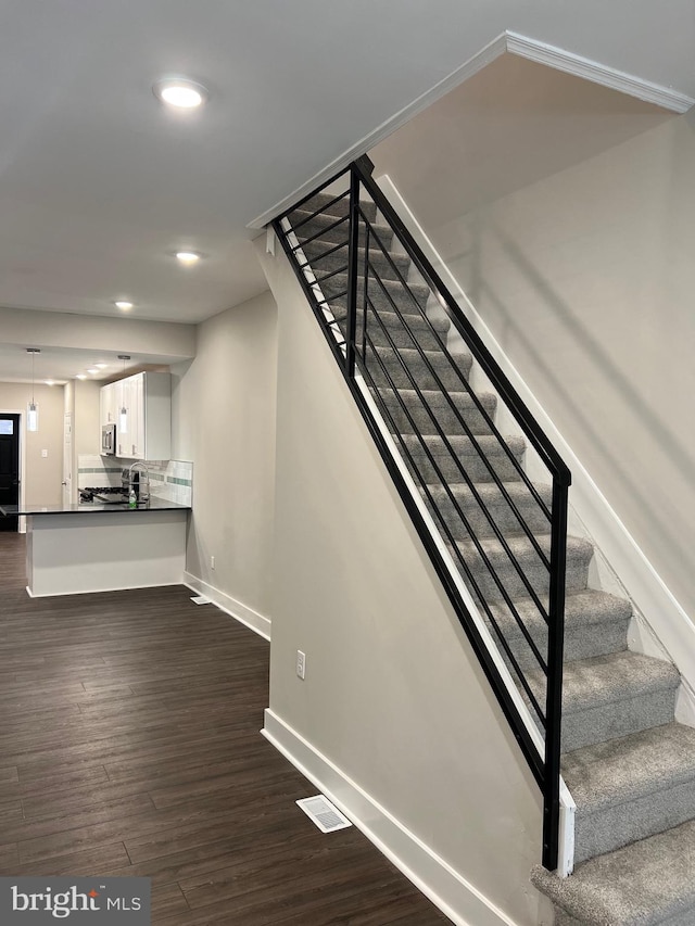 stairs with dark wood-type flooring