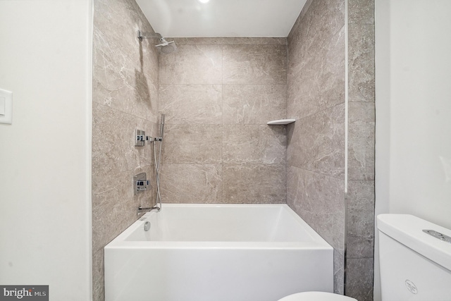 bathroom with tiled shower / bath combo and toilet