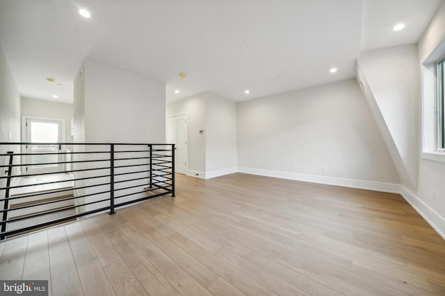 additional living space with light hardwood / wood-style floors and a healthy amount of sunlight