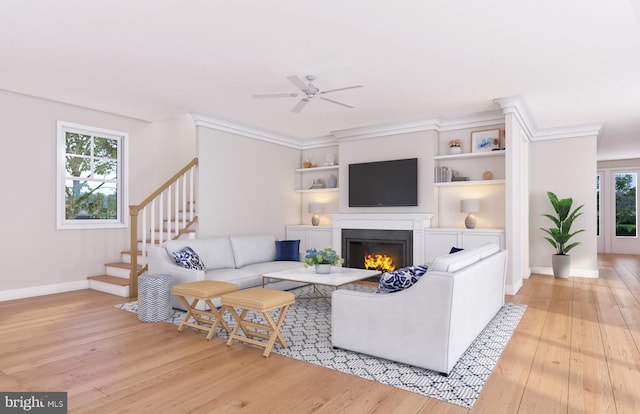 living room with ceiling fan, built in features, light hardwood / wood-style flooring, and a wealth of natural light