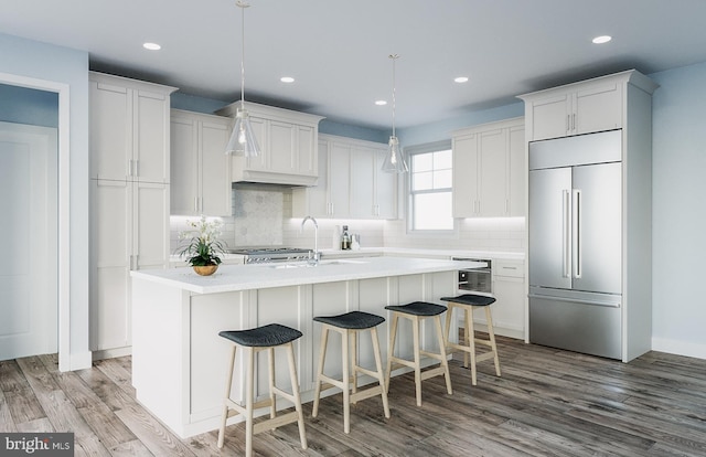 kitchen with white cabinets, light hardwood / wood-style flooring, stainless steel built in fridge, and pendant lighting