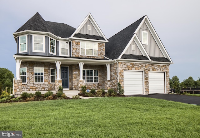 view of front of home featuring a porch, a front yard, and a garage