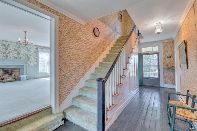 stairway featuring an inviting chandelier, crown molding, and plenty of natural light