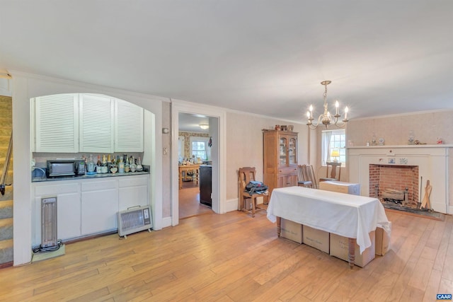 bedroom with crown molding, light hardwood / wood-style flooring, and an inviting chandelier