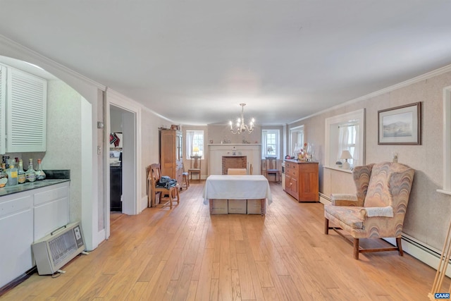 living room with an inviting chandelier, light hardwood / wood-style floors, ornamental molding, and baseboard heating