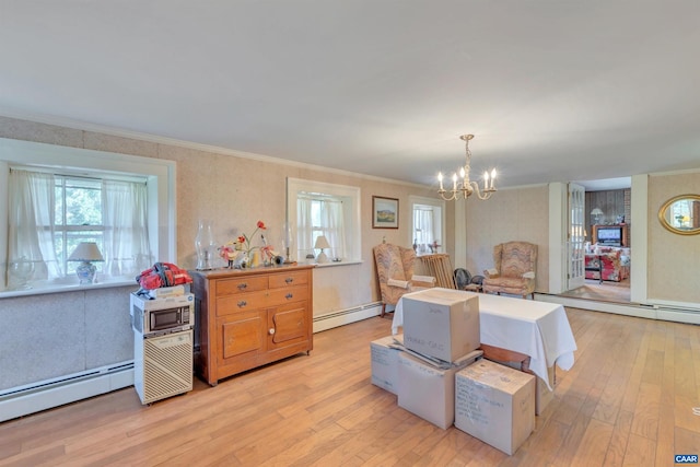 dining room featuring an inviting chandelier, baseboard heating, and light hardwood / wood-style floors