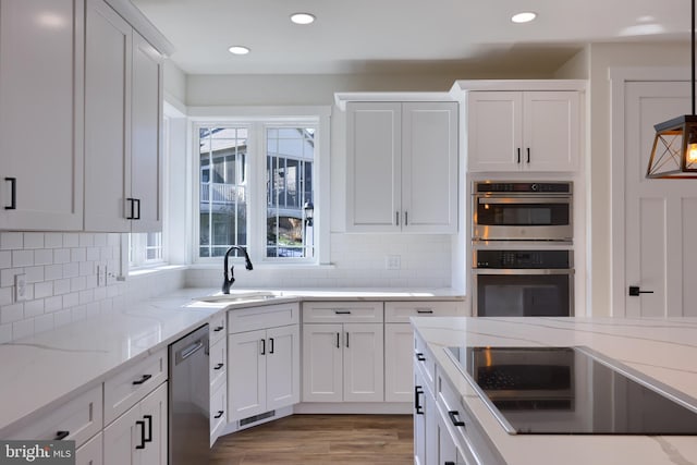 kitchen with appliances with stainless steel finishes, sink, and white cabinetry