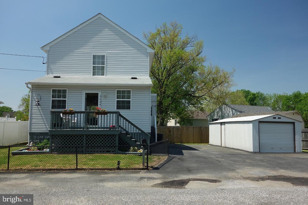 view of front of house featuring a wooden deck, a front yard, an outdoor structure, and a garage