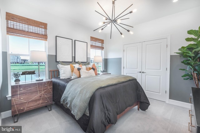 carpeted bedroom featuring a chandelier and a closet