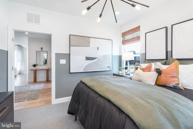 carpeted bedroom featuring an inviting chandelier