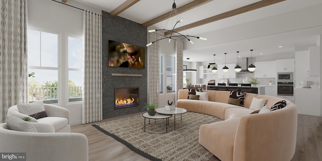 living room with a fireplace, light wood-type flooring, a high ceiling, a notable chandelier, and beam ceiling