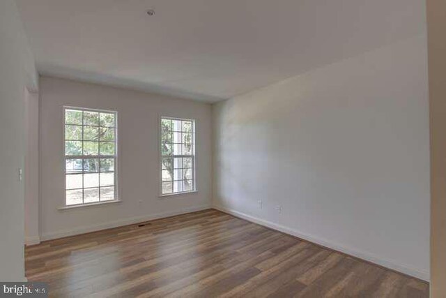 unfurnished room featuring wood finished floors and baseboards